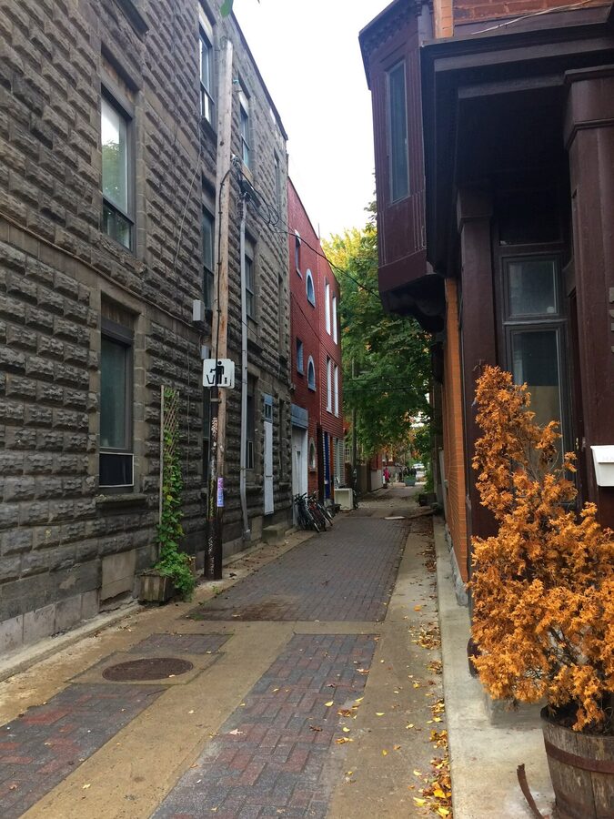 Quiet residential street in Mile End Montreal with stone rowhouses and brick walls