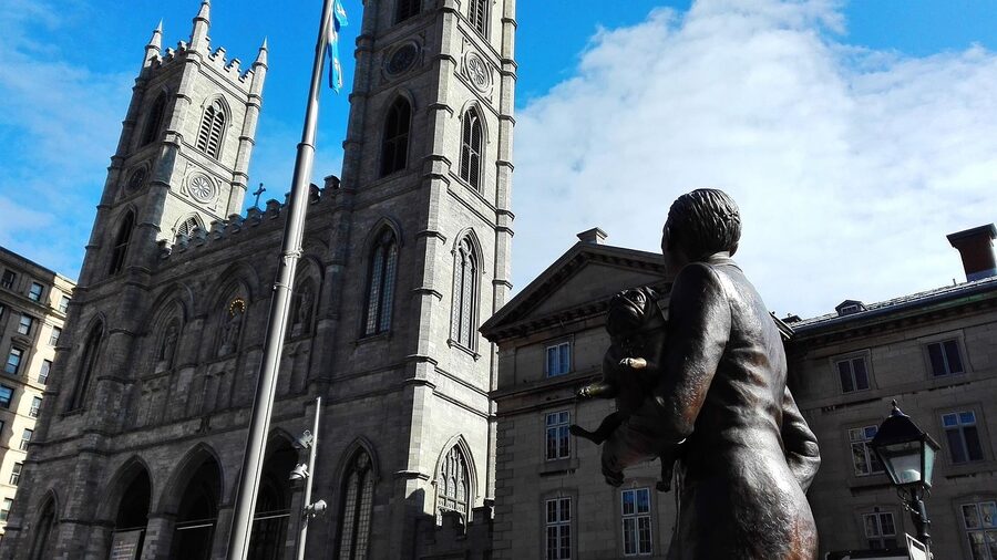 Notre-Dame Basilica seen from Place d'Armes with the Maisonneuve monument silhouetted in the foreground